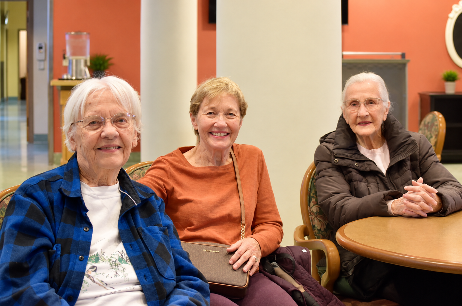 Three residents smiling together at Legacy Court Senior Living in Spokane, Washington